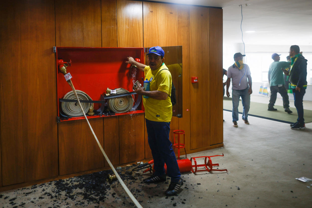 Supporters of Brazil's former President Jair Bolsonaro vandalize the interior of Planalto Palace, breaking out the glass containing a set of firehoses and a fire extinguisher.