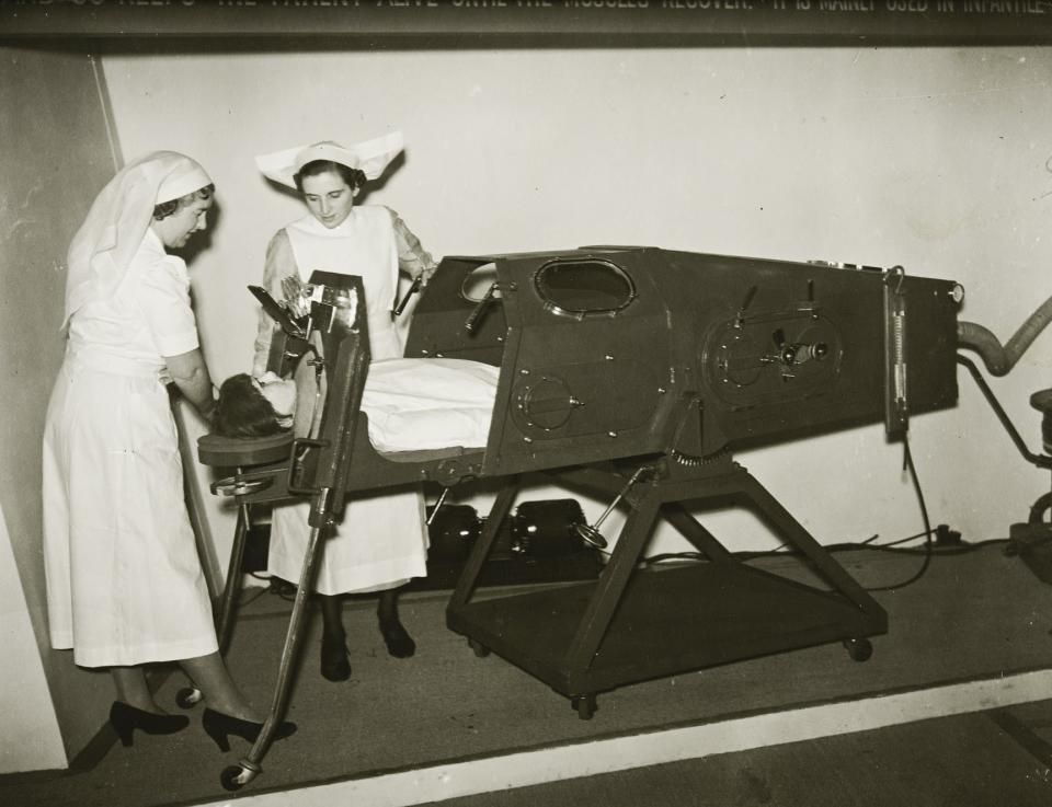Two nurses operating an iron lung at an exhibition in Charing Cross underground station