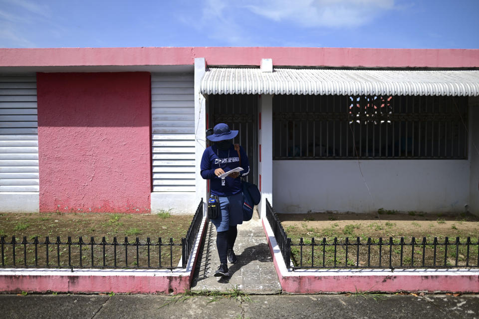 Postal worker Jose Montoya does his rounds in Carolina, Puerto Rico, Thursday, Oct. 1, 2020. More than half of all homes in Puerto Rico lack a physical address, so the absence of street names and numbers also have created multiple problems ranging from ambulances unable to reach a home in time to a delay in the distribution of aid after Hurricane Maria and a string of recent earthquakes. (AP Photo/Carlos Giusti)