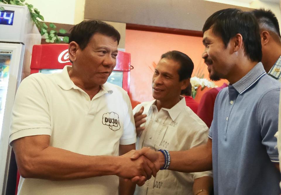 Manny Pacquiao, right, shakes hands with Phillipines president Rodrigo Duterte. (AFP)