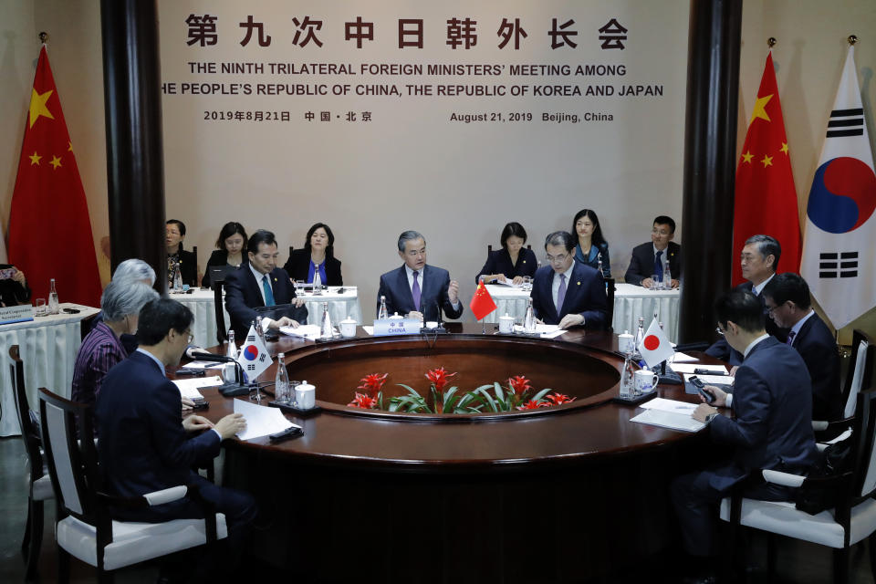 Chinese Foreign Minister Wang Yi, center, speaks during a trilateral meeting with his South Korean counterpart Kang Kyung-wha, left, and Japanese counterpart Taro Kono, right, at Gubei Town in Beijing Wednesday Aug. 21, 2019. (Wu Hong/Pool Photo via AP)