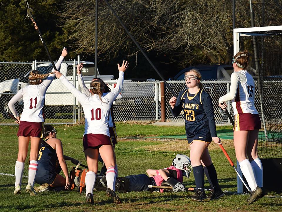 Case's Jenna Benfeito, hidden, celebrates with teammates after scoring the Cardinals' first goal late in the fourth quarter.