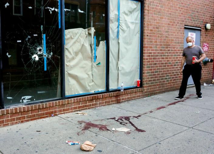 Bloodstains and bullet holes can be seen on South Street, Philadelphia (AP)