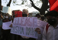 FILE - In this Feb. 15, 2021, file photo, prominent Indian historian Ramachandra Guha, center, holds a placard demanding the release of Indian climate activist Disha Ravi during a protest in Bengaluru, India. Ravi, a 22-year-old climate activist in India, was arrested and charged with sedition last month for sharing an online handbook meant to help raise support for farmer protests that have convulsed India. The incident has called into question the state of India’s democracy, with observers decrying it as the latest attempt by Prime Minister Narendra Modi’s Hindu nationalist government to mute dissent. Guha said previous governments have also tried to control independent institutions but “a recovery, even a partial one,” always followed. “I fear that this time our democratic traditions may not be able to recover from this assault,” he said. (AP Photo/Aijaz Rahi, File)