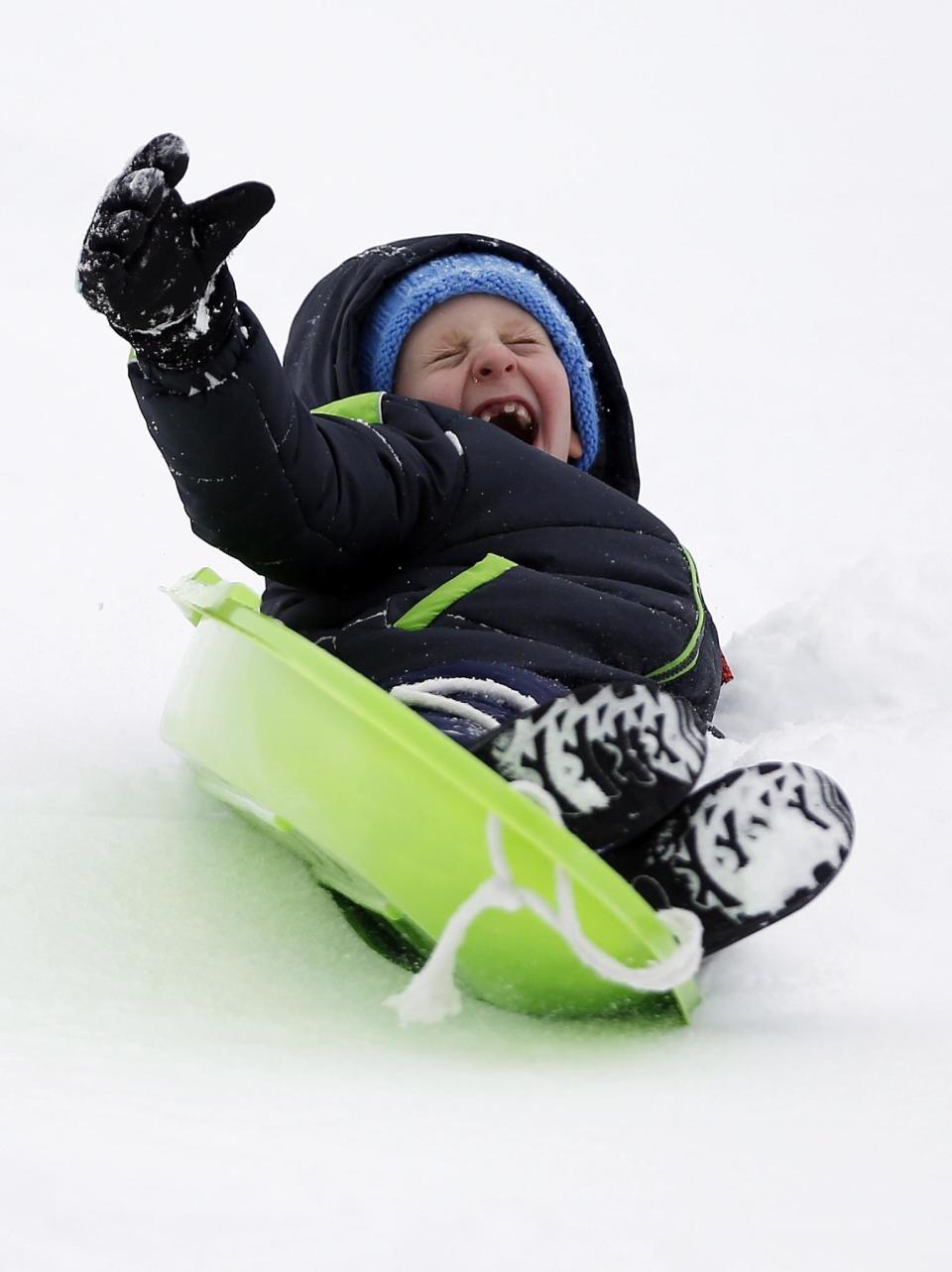 Mitchell Clark, 7, slides down a hill during his first sledding of the season at Reid Middle School in Pittsfield, Mass., on Saturday, Dec. 17, 2016. A winter storm of snow, freezing rain and bone-chilling temperatures hit the nationss mid-section and East Coast on Saturday. (Stephanie Zollshan/The Berkshire Eagle via AP)