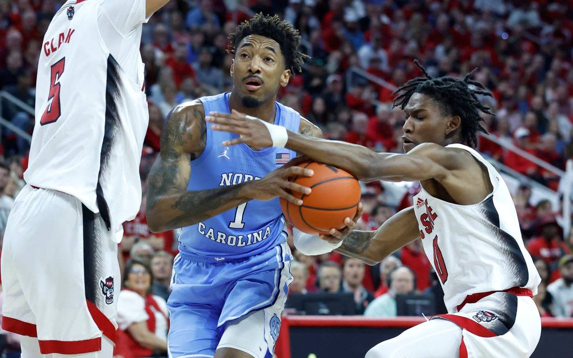 N.C. State’s Terquavion Smith (0) knocks the ball from North Carolina’s Leaky Black (1) during the first half of N.C. State’s game against UNC at PNC Arena in Raleigh, N.C., Sunday, Feb. 19, 2023.