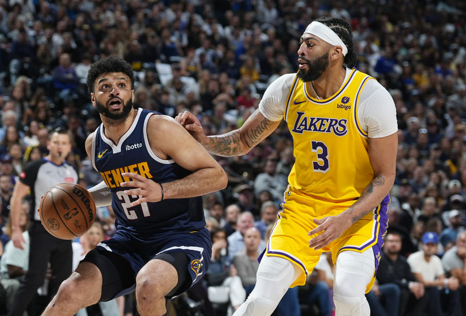 Denver Nuggets guard Jamal Murray, left, drives to the basket as Los Angeles Lakers forward Anthony Davis, right, defends in the first half of Game 5 of an NBA basketball first-round playoff series Monday, April 29, 2024, in Denver. (AP Photo/David Zalubowski)