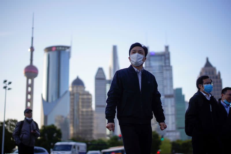 FILE PHOTO: FILE PHOTO: People wear protective face masks, following an outbreak of the novel coronavirus disease (COVID-19), at Lujiazui financial district in Shanghai