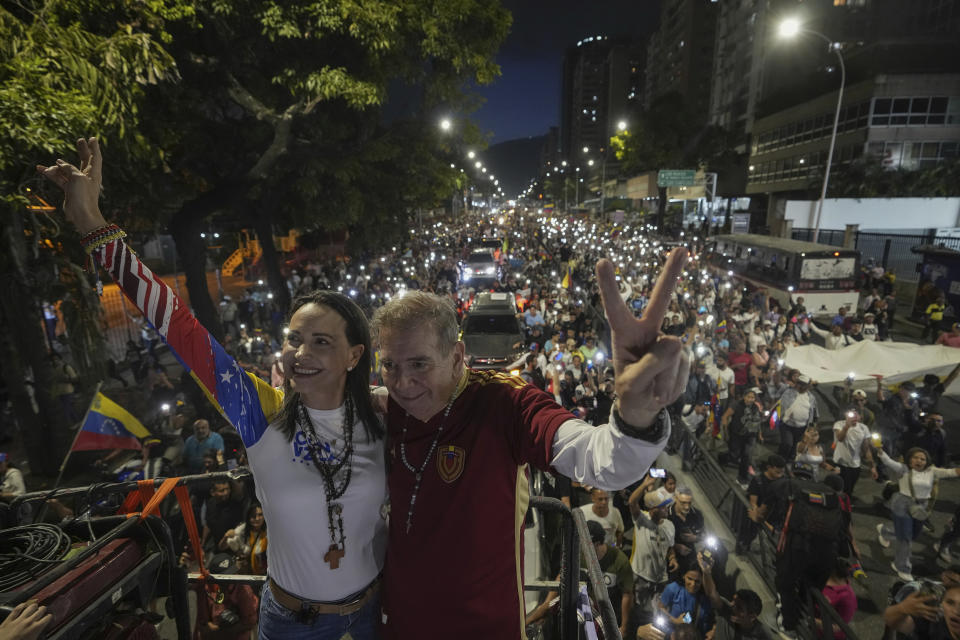 La líder opositora María Corina Machado, a la izquierda, y el candidato presidencial Edmundo González saludan a la multitud en el acto de inicio de la campaña electoral en Caracas, Venezuela, el jueves 4 de julio de 2024. Venezuela va a elecciones presidenciales el domingo 28 de julio. (AP Foto/Ariana Cubillos)