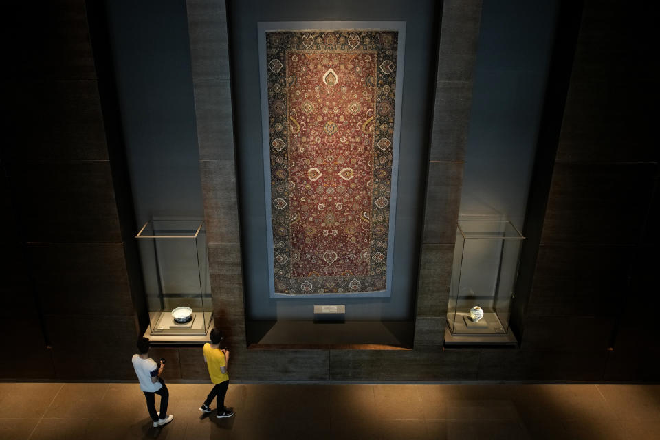 Visitors view an Iranian carpet at the Museum of Islamic Art in Doha, Qatar, Tuesday, Nov. 22, 2022. (AP Photo/Christophe Ena)