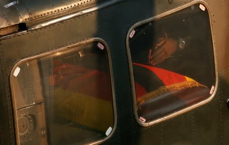 Robert Mugabe Junior's hands are seen near a casket carrying the remains of his father, Robert Mugabe, after his body was loaded on a military chopper before leaving the Rufaro stadium