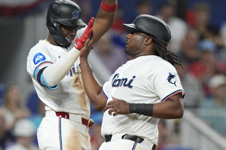 Miami Marlins' Josh Bell, right, is congratulated by Jesus Sanchez after Bell scored on a sacrifice fly ball hit by Jake Burger during the fifth inning of a baseball game against the Pittsburgh Pirates, Thursday, March 28, 2024, in Miami. (AP Photo/Wilfredo Lee)