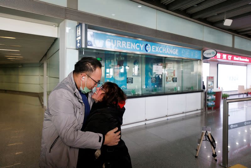 FILE PHOTO: People embrace at the international arrivals gate at Beijing Capital International Airport after China lifted the COVID-19 quarantine requirement for inbound travellers in Beijing