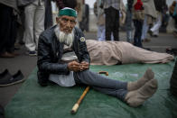 87-year old farmer Mohammad Abid listens to a speaker along with fellow farmers as they block a major highway in a protest against new farm laws at the Delhi-Uttar Pradesh state border, India, Friday, Jan. 8, 2021. (AP Photo/Altaf Qadri)