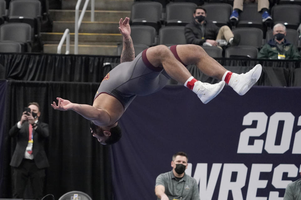 FILE - Minnesota's Gable Steveson does a backflip to celebrate after defeating Michigan's Mason Parris in their 285-pound match in the finals of the NCAA wrestling championships in St. Louis, in this Saturday, March 20, 2021, file photo. The charismatic 21-year-old hopes a successful run at the Games launches him into a WWE career like his mentor, Brock Lesnar, and an acting career like former WWE star Dwayne 'The Rock' Johnson. (AP Photo/Jeff Roberson, File)