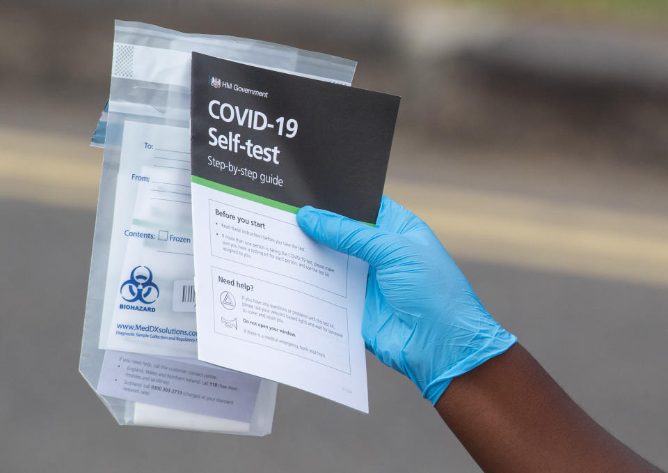 Staff hand out self test kits at a Coronavirus testing centre in Southwark, London.