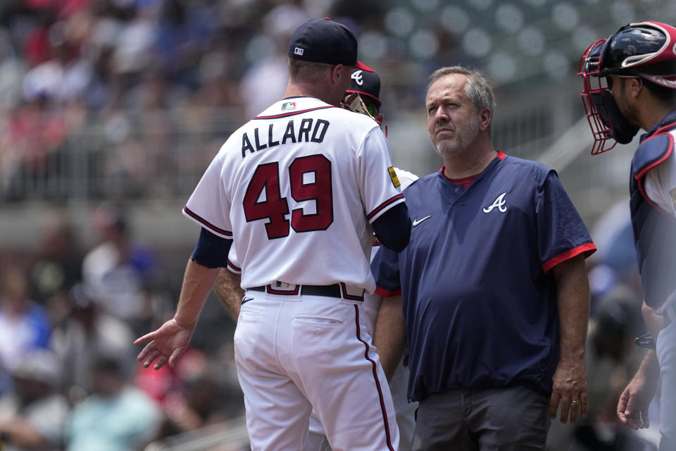 A member of Atlanta Braves training staff checks on pitcher Kolby Allard (49) in the second inning of a baseball game against the Chicago White Sox Sunday, July 16, 2023, in Atlanta. Allard left the game. (AP Photo/John Bazemore)