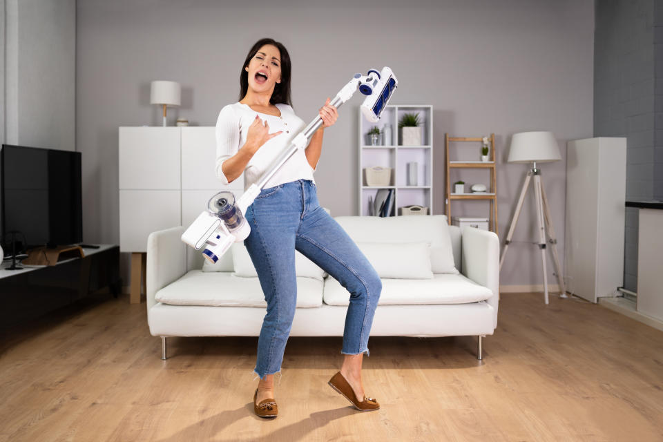 person dancing with their vacuum