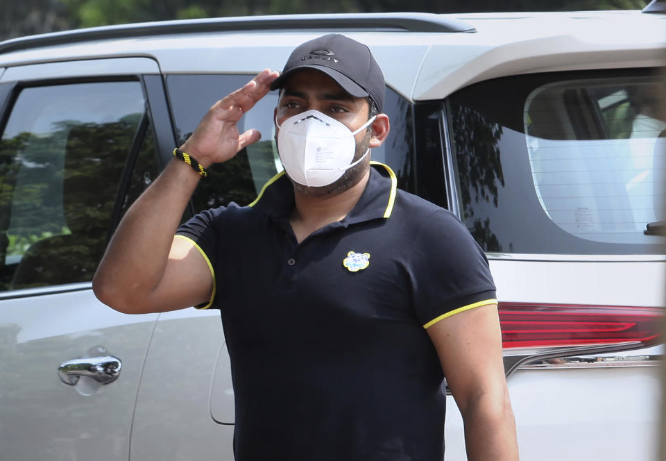 Pakistani cricketer Umar Akmal salutes to media while he arrives at the Pakistan Cricket Board office in Lahore, Pakistan, Wednesday, July 29, 2020. An independent adjudicator has halved batsman Akmal's ban to 18 months for failing to report corrupt approaches before this year's Pakistan Super League. (AP Photo/K.M. Chaudhry)