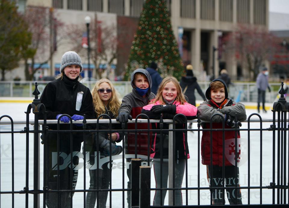 Neighborhood kids from June Street, Lauren Church, left, Emily Benoit, Nathan Church, Madeleine Church and Ethan Benoit pause for a photo while skating at the Worcester Common Oval outdoor ice rink on Sunday.