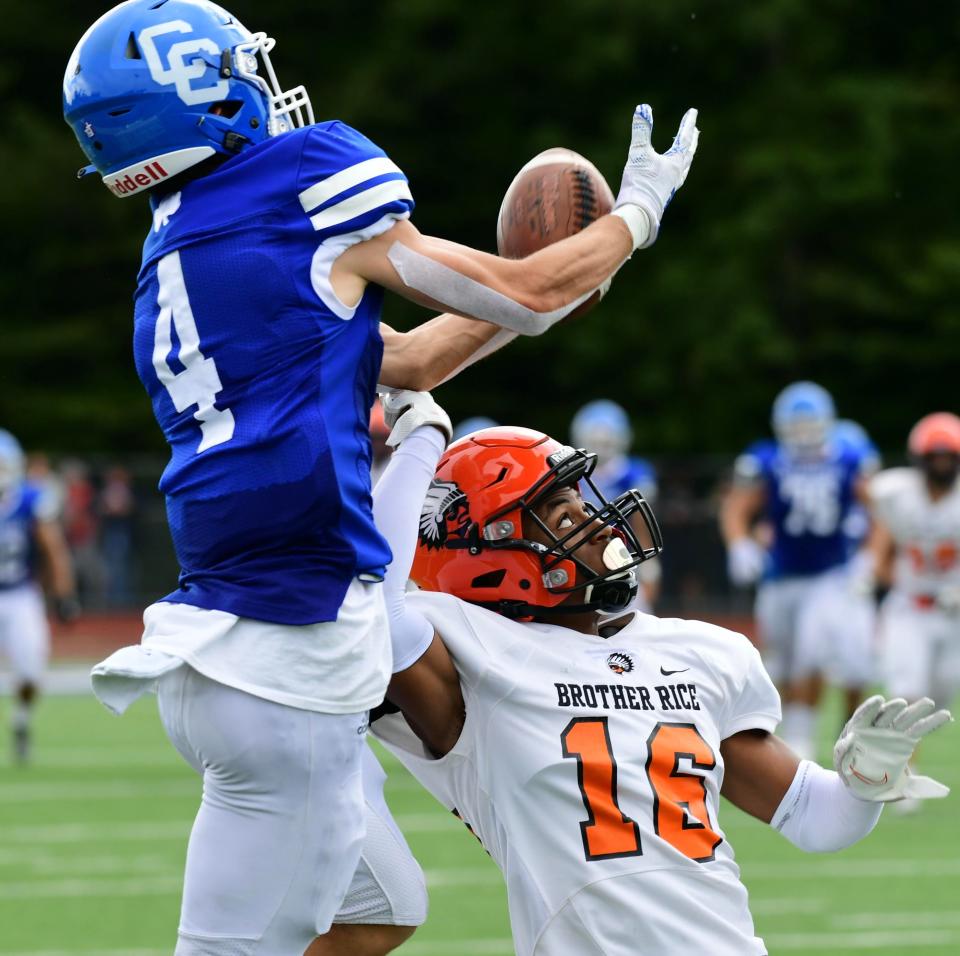 Detroit Catholic Central's Owen Semp (left) catches a pass over Brother RIce's Jaeden Johnson during a Catholic League-Central football game on Sunday, Sept. 26, 2021.