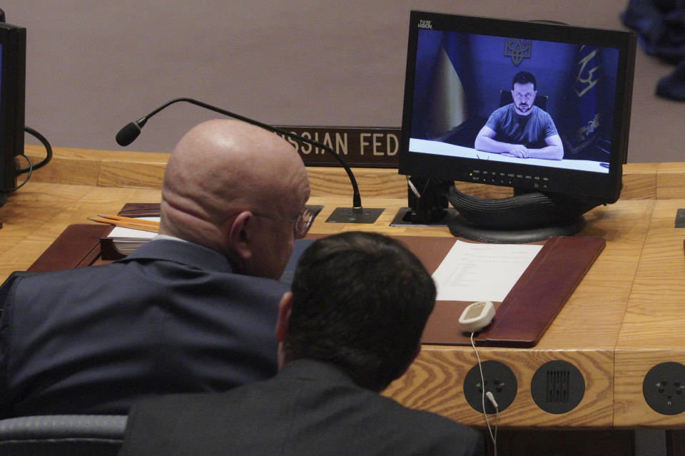 Russia's United Nations Ambassador Vasily Nebenzya, left, confers with an aide, while Ukraine President Volodymyr Zelenskyy addresses the United Nations Security Council by video, Tuesday Sept. 27, 2022, at U.N. headquarters. (AP Photo/Bebeto Matthews)