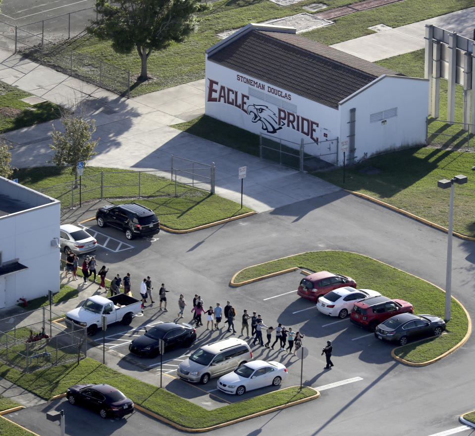 FILE - Students are evacuated by police from Marjory Stoneman Douglas High School, Wednesday, Feb. 14, 2018, in Parkland, Fla., after a shooter opened fire on the campus. A reenactment of the 2018 massacre that left 17 dead, 17 wounded and hundreds emotionally traumatized, is scheduled to be conducted Friday, Aug. 4, 2023, as part of lawsuits filed by the victims' families and the injured. (Mike Stocker/South Florida Sun-Sentinel via AP, File)