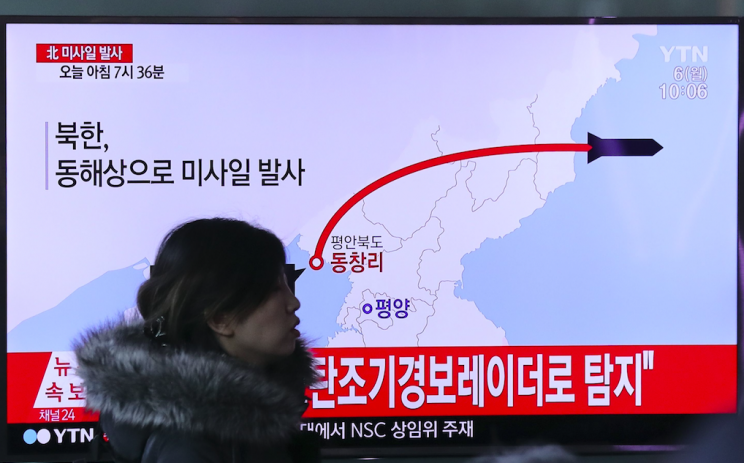 A visitor walks by a TV screen in Seoul showing a news report about a recent North Korean missile firing (Pictures: AP)