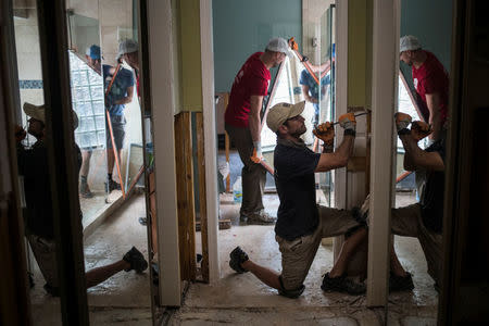 Ben Hyman and other samaritans help clear debris from the house of a neighbor which was left flooded from Tropical Storm Harvey in Houston, Texas, U.S. September 3, 2017. REUTERS/Adrees Latif