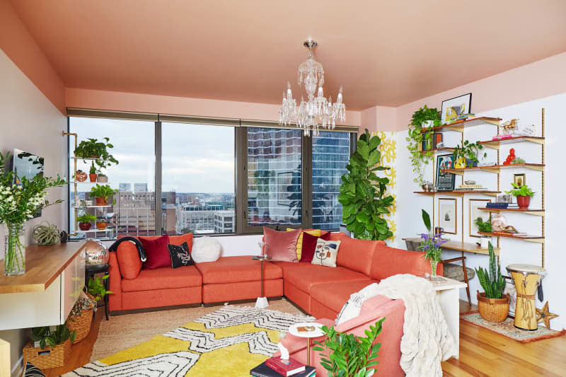 Large pink sectional in living room with pink painted ceilings.