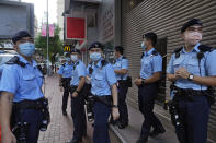 Police officers stand guard at a street during a protest against an election committee that will vote for the city's leader in Hong Kong Sunday, Sept. 19, 2021. Hong Kong's polls for an election committee that will vote for the city's leader kicked off Sunday amid heavy police presence, with chief executive Carrie Lam saying that it is "very meaningful" as it is the first election to take place following electoral reforms. (AP Photo/Vincent Yu)