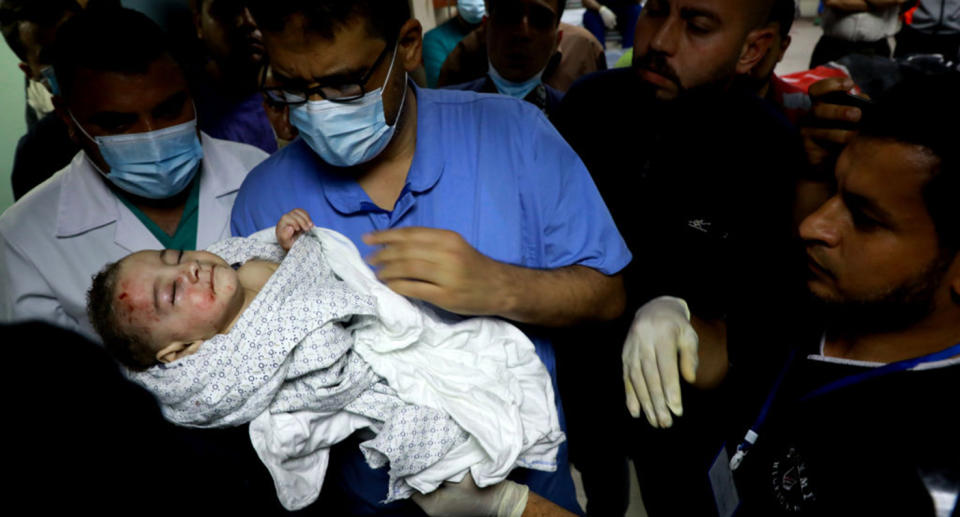 A nurse at at Al-Shifa Hospital holds a baby who was pulled alive from under the rubble while seven other family members perished after an Israeli air strike at Al-Shati Refugee Camp on May 15, 2021.