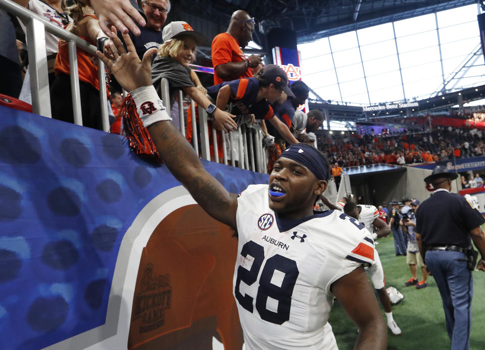 Auburn running back JaTarvious Whitlow (28) celebrates with fans after Auburn defeated Washington 21-16 in an NCAA college football game Saturday, Sept. 1, 2018, in Atlanta. (AP Photo/John Bazemore)