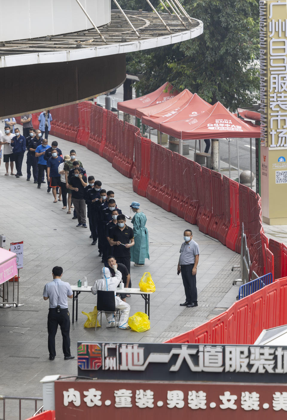 People line up for COVID-19 screening at an apparel wholesale market enclosed by a temporary wall in Guangzhou, in south China's Guangdong province, November 10, 2022. / Credit: JULIEN TAN/Feature China/Future Publishing/Getty