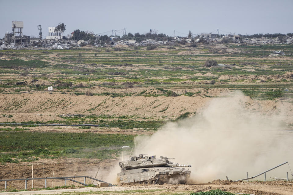 Israeli soldiers drive a tank inside Gaza Strip, as seen from southern Israel, Tuesday, Feb. 13, 2024. The army is battling Palestinian militants across Gaza in the war ignited by Hamas' Oct. 7 attack into Israel. (AP Photo/Ariel Schalit)