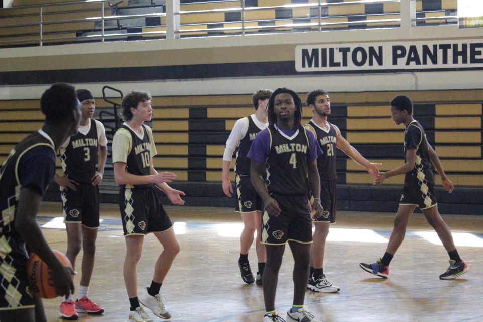 Several Milton boys basketball players wait for their turn during a drill during the Panthers' practice on Monday, Dec. 18, 2023.