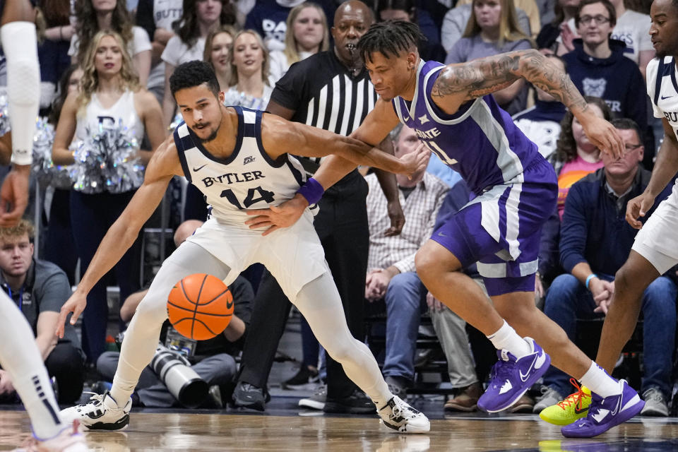 Butler guard Pierce Thomas (14) is fouled by Kansas State forward Keyontae Johnson (11) as they go for a loose ball in the first half of an NCAA college basketball game in Indianapolis, Wednesday, Nov. 30, 2022. (AP Photo/Michael Conroy)