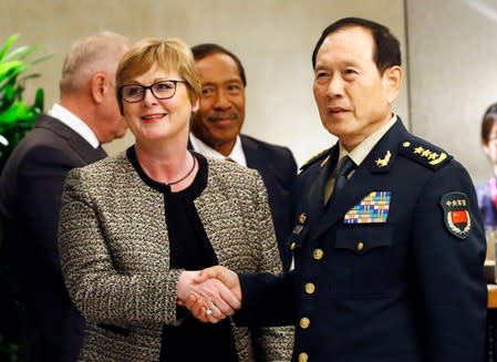 Australian Defense Minister Linda Reynolds and Chinese Defense Minister Wei Fenghe shake hands at a ministerial roundtable at the IISS Shangri-la Dialogue in Singapore