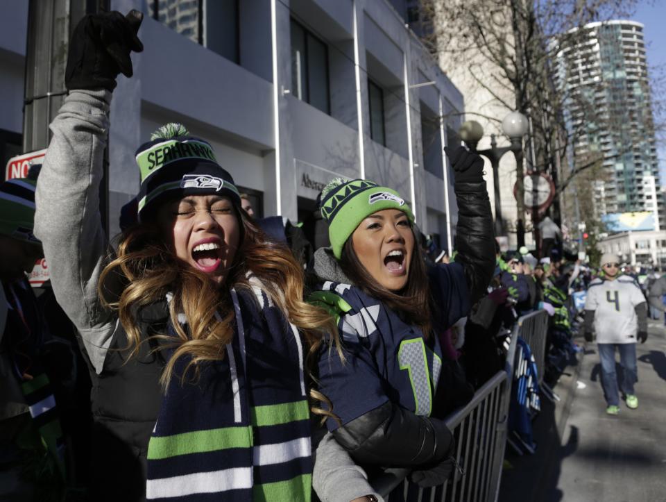Western Washington University students Teena Thach (L), 21, and Shawna Mori, 20, stand along 4th Avenue at the Super Bowl victory parade for the Seattle Seahawks in downtown in Seattle, Washington February 5, 2014. Up to 500,000 Seattle Seahawks fans were expected to brave sub-freezing temperatures to celebrate the football team's first Super Bowl title at a parade set to wind through the city's downtown on Wednesday. REUTERS/Jason Redmond (UNITED STATES - Tags: SPORT FOOTBALL EDUCATION)
