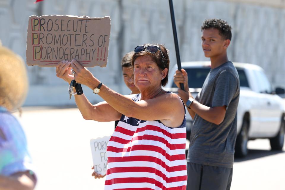 A woman holds a sign in support of County Citizens Defending Freedom along South Padre Island Drive in Flour Bluff near the organization's office Saturday, July 9, 2022.
