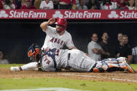 Los Angeles Angels' Jack Mayfield, top, is tagged out at home by Houston Astros catcher Martin Maldonado while trying to score after Jose Rojas was safe at first on a fielding error by second baseman Jose Altuve during the sixth inning of a baseball game Thursday, Sept. 23, 2021, in Anaheim, Calif. (AP Photo/Mark J. Terrill)