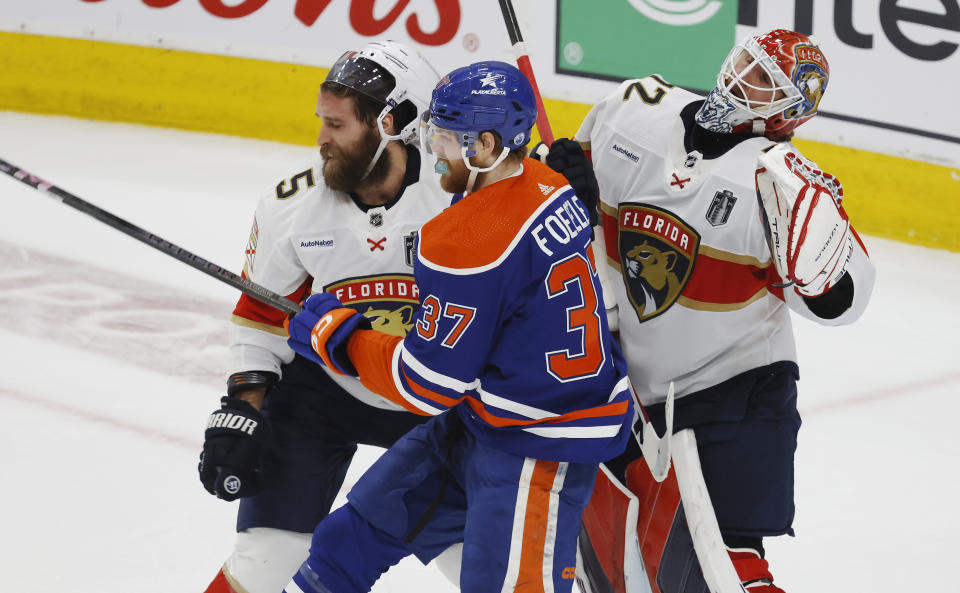 Florida Panthers' Aaron Ekblad (5) and Edmonton Oilers' Warren Foegele (37) work in front of Panther goaltender Sergei Bobrovsky (72) during the first period of Game 6 of the NHL hockey Stanley Cup Final, Friday, June 21, 2024, in Edmonton, Alberta. (Jeff McIntosh/The Canadian Press via AP)