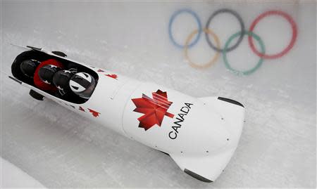 Canada's pilot Justin Kripps (front) and his teammates speed down the track during a four-man bobsleigh training session at the Sanki Sliding Center in Rosa Khutor, during the Sochi 2014 Winter Olympics February 19, 2014. REUTERS/Arnd Wiegmann