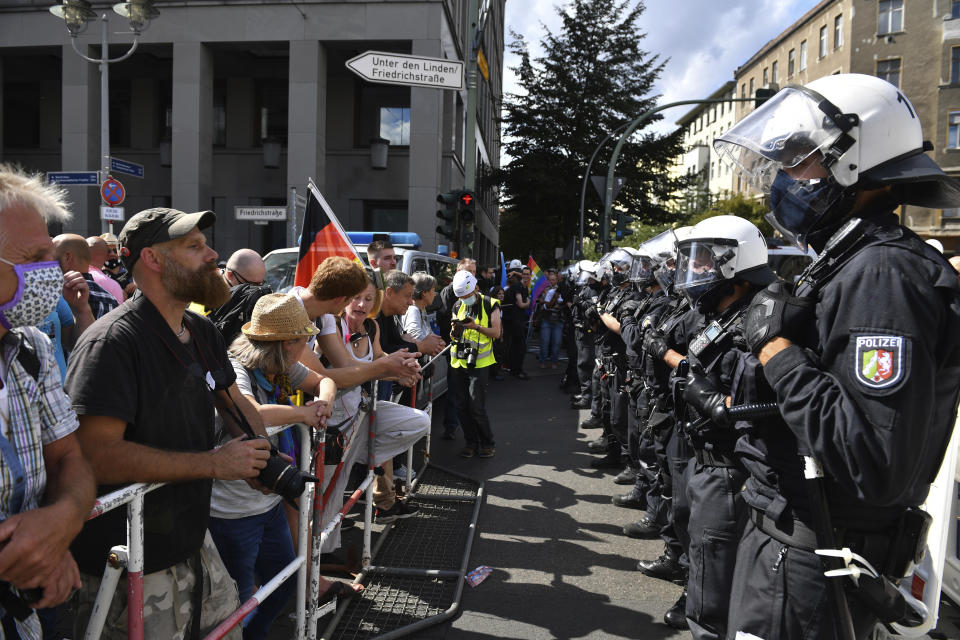 A police chain stands opposite the participants in a demonstration against the Corona measures at barrier bars in Berlin, Germany, Saturday, Aug. 29, 2020. (Bernd Von Jutrczenka/dpa via AP)