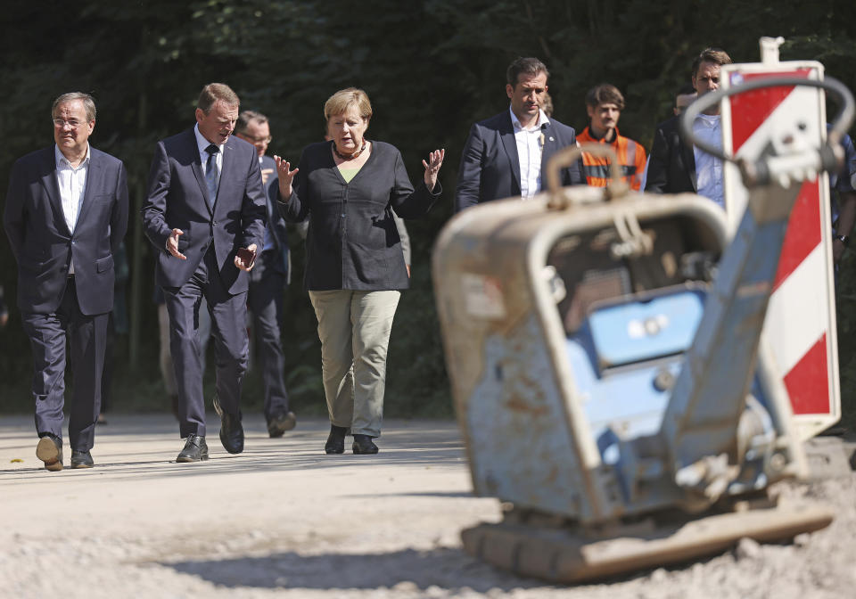 German Chancellor Angela Merkel, centre, walks with Armin Laschet, left, candidate for chancellor of the CDU/CSU and chairman of the CDU, and Fritz J'ckel, second from left, North Rhine-Westphalia's commissioner for reconstruction in flooded areas, as they vistit areas affected by flooding, in Hagen, Germany, Sunday, Sept. 5, 2021. (Oliver Berg/Pool Photo via AP)