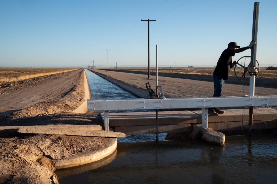 Jeff Dollente, a zanjero with the Imperial Irrigation District, opens a gate on the Redwood Canal north of El Centro, California, on June 1, 2022. Dollente moved 119-acre feet of water during his shift.