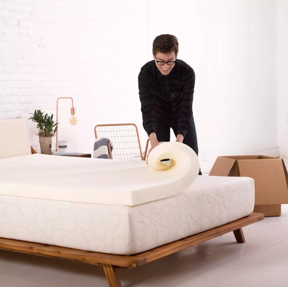 model putting the topper on a mattress