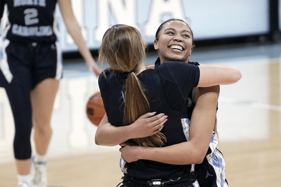 North Carolina guard Stephanie Watts, right, hugs guard Alyssa Ustby following an NCAA college basketball game against North Carolina State in Chapel Hill, N.C., Sunday, Feb. 7, 2021. (AP Photo/Gerry Broome)
