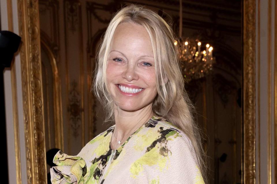 <p>Francois Goize/WWD via Getty</p> Pamela Anderson smiles at the Victoria Beckham Ready To Wear Spring 2024 show