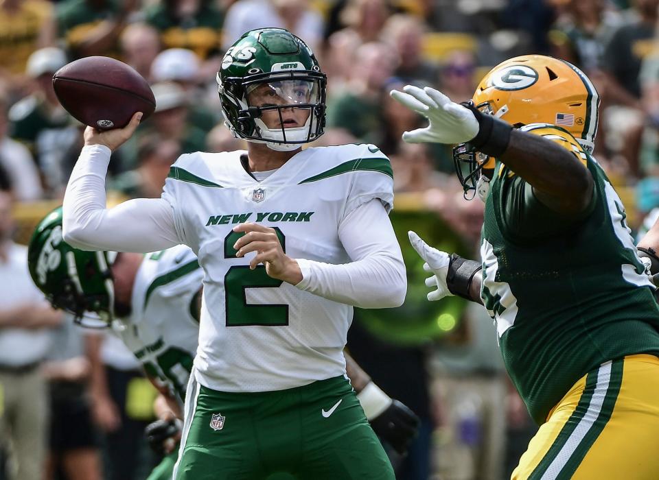 Aug 21, 2021; Green Bay, Wisconsin, USA;  New York Jets quarterback Zach Wilson (2) gets a pass away while under pressure from Green Bay Packers defensive tackle T.J. Slaton (93) in the first quarter at Lambeau Field.